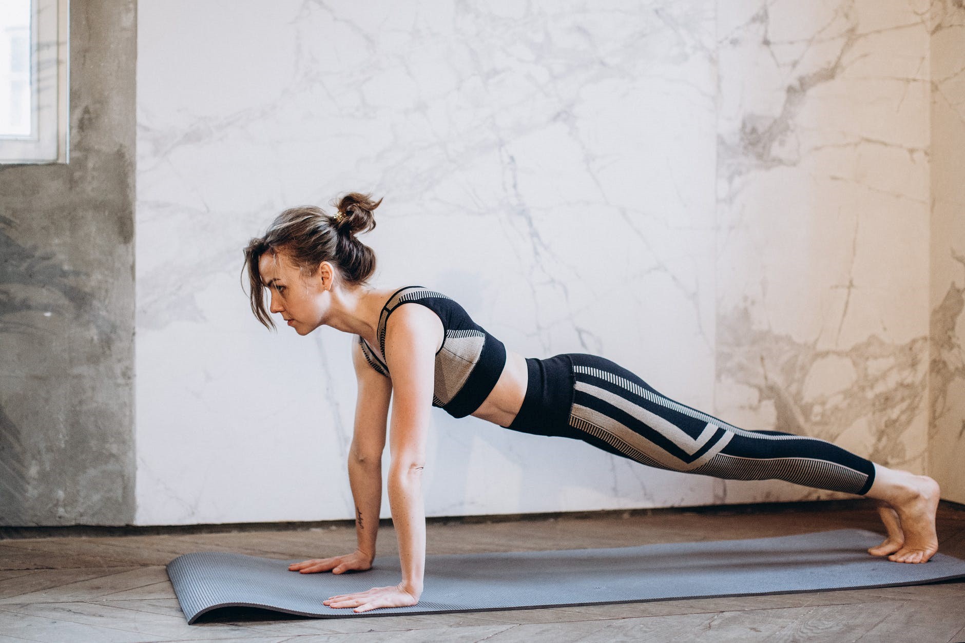 A woman doing push-ups on an exercise mat