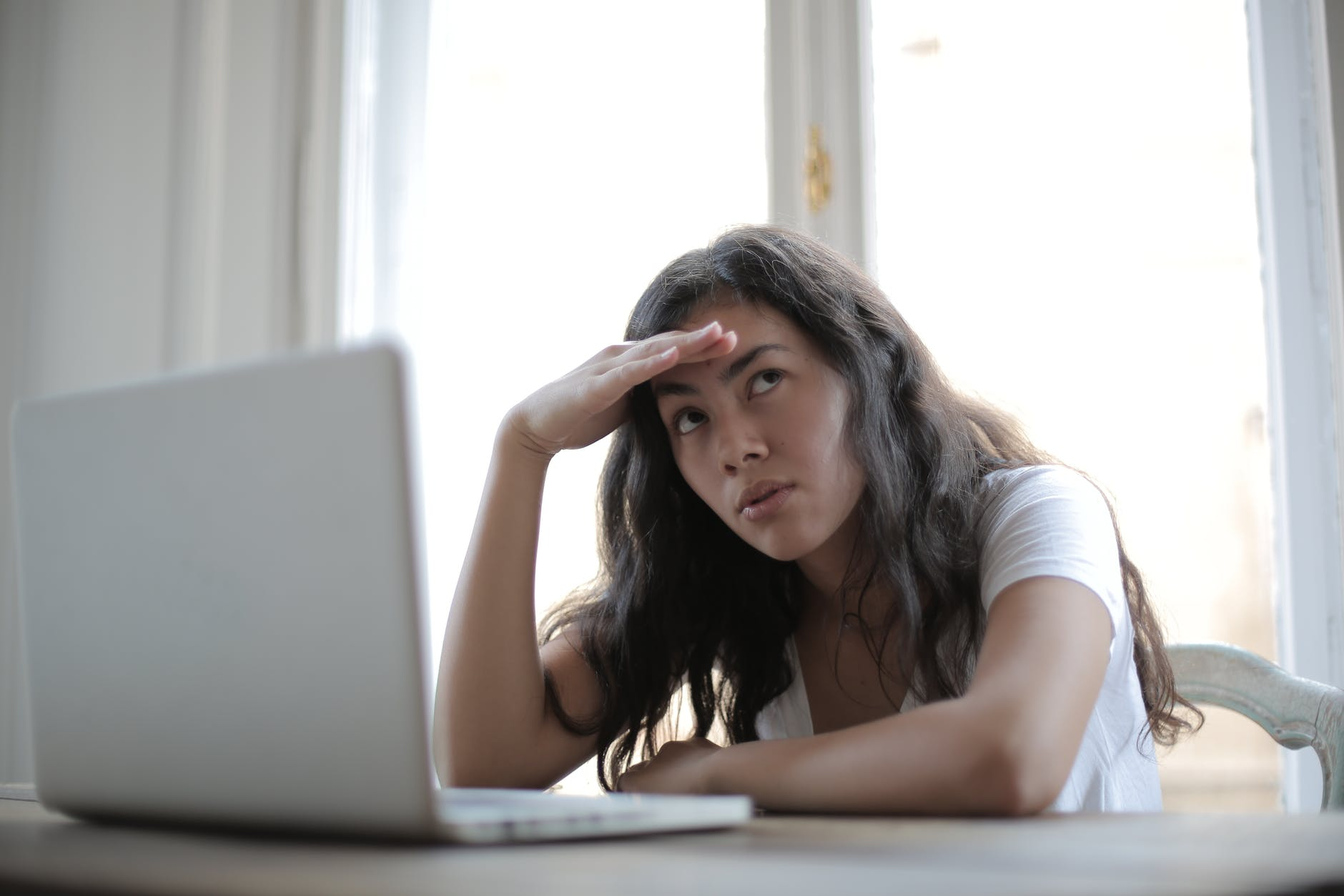 A stressed woman sitting in front of the laptop