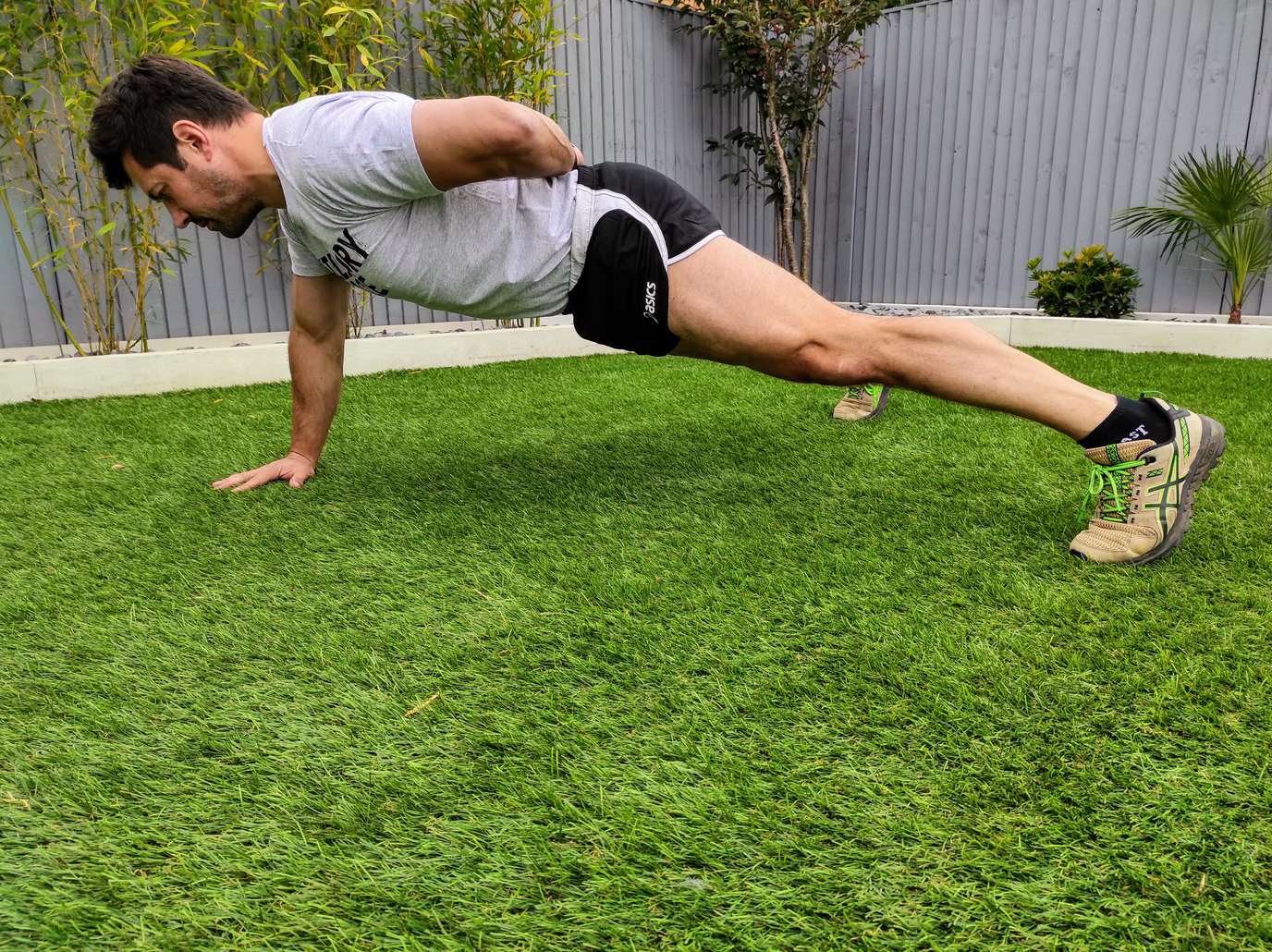 Person doing a calisthenics push-up in their garden