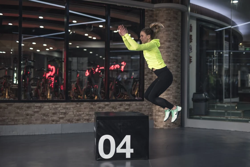 A woman mid-air through a bodyweight strength jumping jack 
